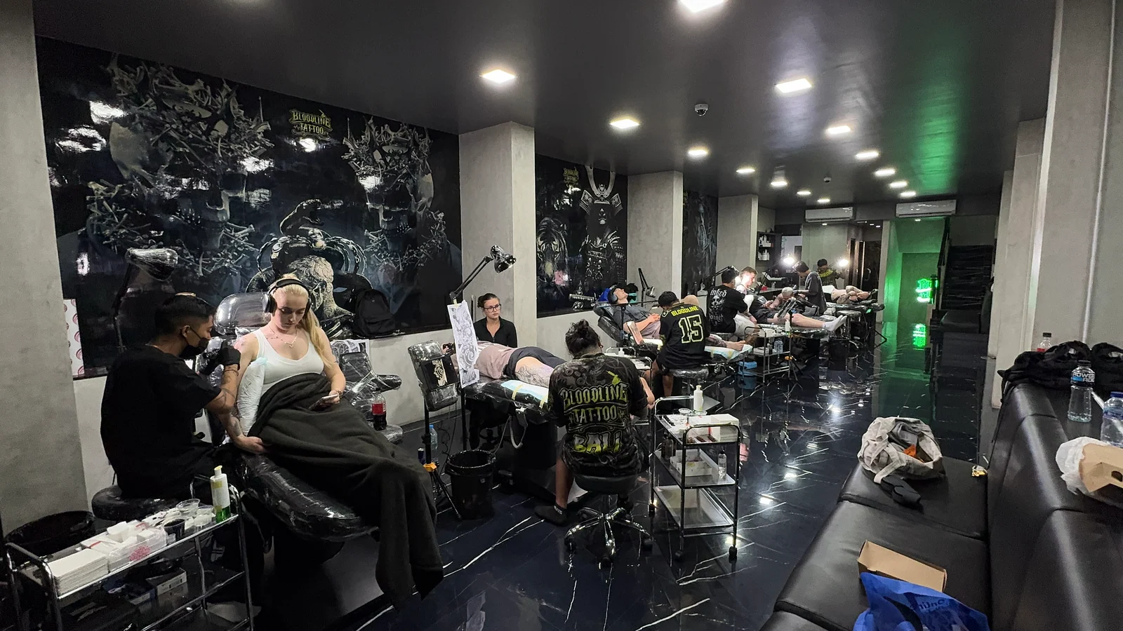 Bloodline Tattoo Bali studio floor with artists at work and Bloodline Bali branding